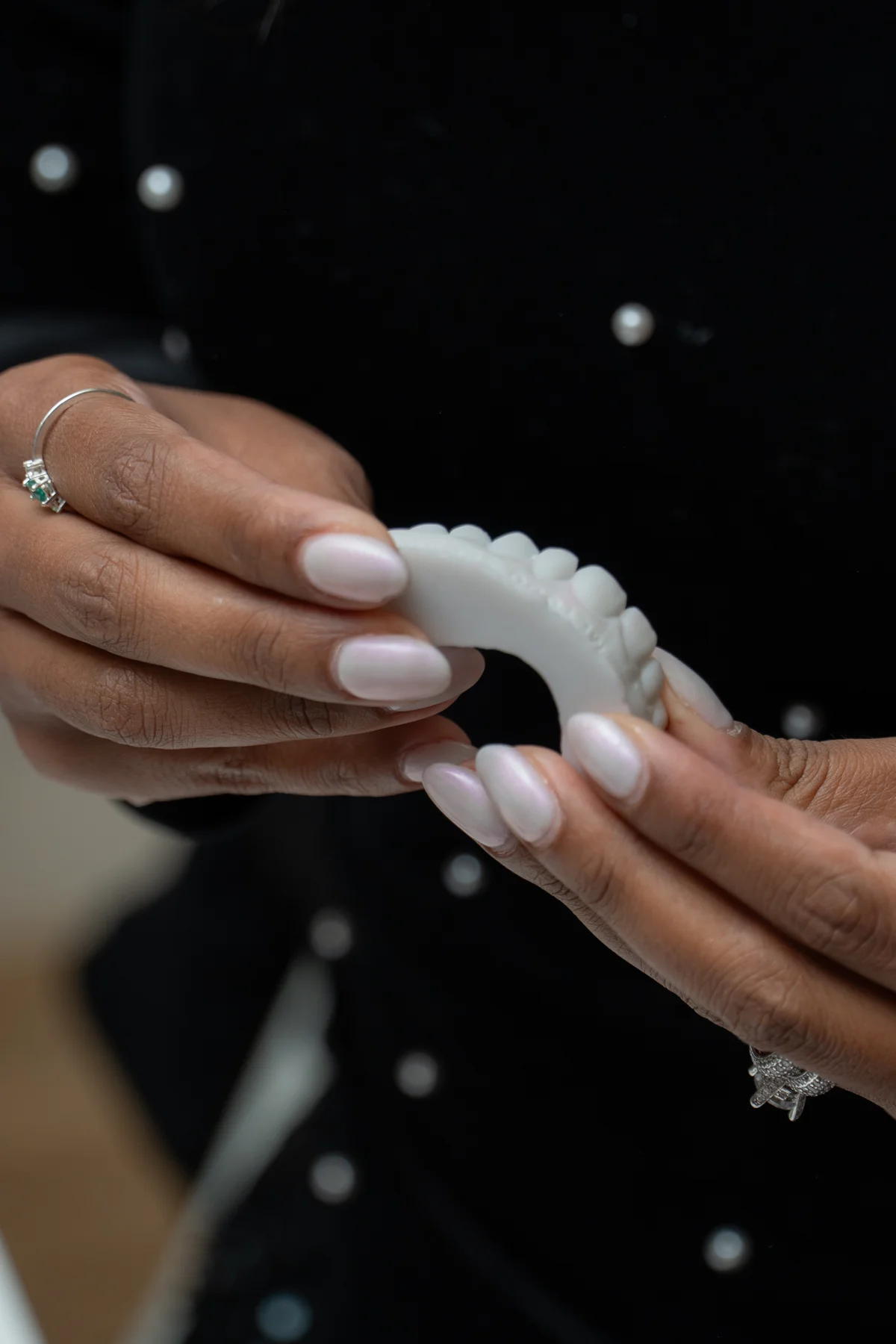 Participante analisando um modelo de dentes durante a discussão de lentes de porcelana.