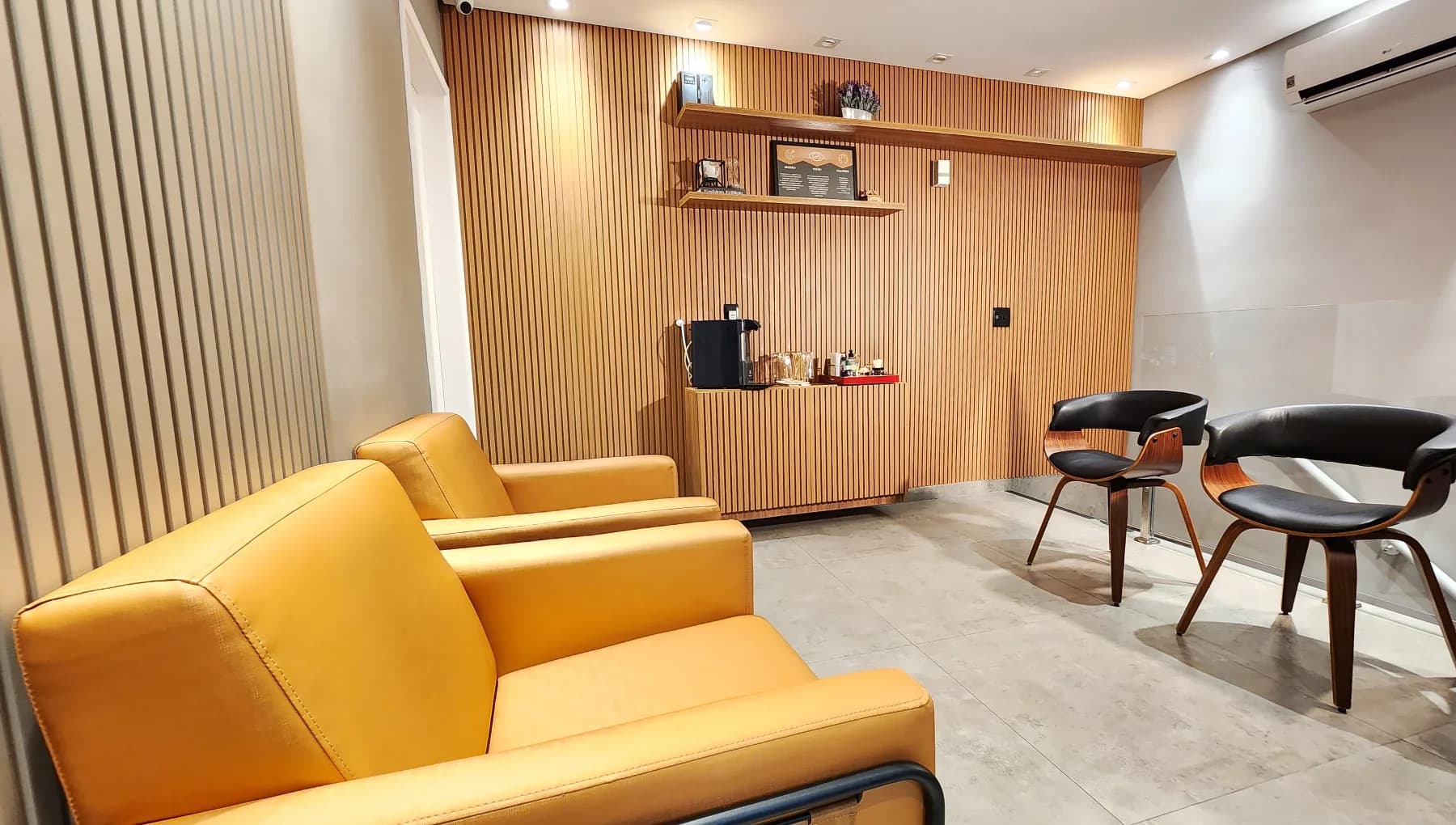 Espaço de recepção da Allegra Odontologia com poltronas e mesa de apoio.