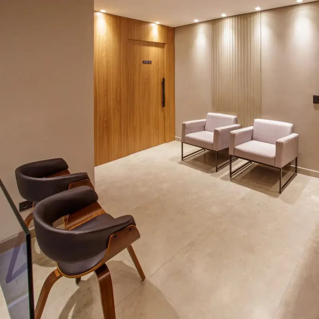 Sala de espera da Allegra Odontologia, com iluminação acolhedora e acabamentos em madeira.